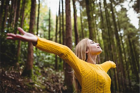 simsearch:6109-08481684,k - Beautiful blonde woman with arms outstretched in the woods Foto de stock - Sin royalties Premium, Código: 6109-08481691