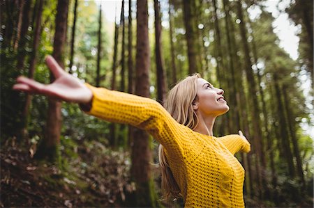 simsearch:6109-08481684,k - Beautiful blonde woman with arms outstretched in the woods Foto de stock - Sin royalties Premium, Código: 6109-08481692