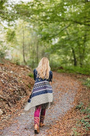 poncho - Beautiful blonde woman walking on road surrounded by forest Stock Photo - Premium Royalty-Free, Code: 6109-08481710