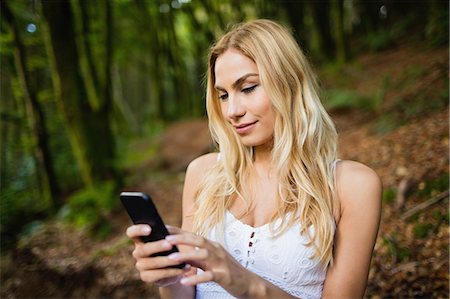 simsearch:6109-08481684,k - Beautiful blonde woman using smartphone in the woods Foto de stock - Sin royalties Premium, Código: 6109-08481725