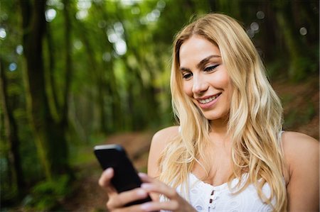 simsearch:6109-08481688,k - Beautiful blonde woman using smartphone in the woods Photographie de stock - Premium Libres de Droits, Code: 6109-08481726