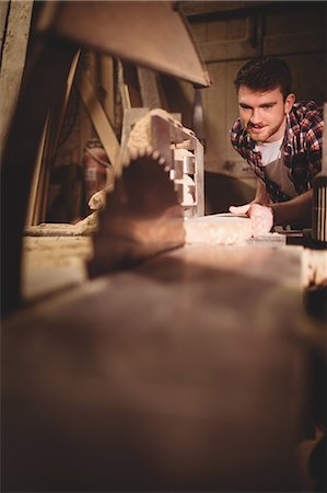 simsearch:6102-07158067,k - Carpenter working on his craft in a dusty workshop Stock Photo - Premium Royalty-Free, Code: 6109-08481891