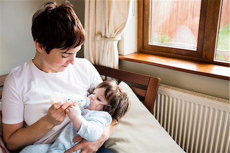 simsearch:6109-08390041,k - Cute mother bottle feeding her baby in the bedroom Stock Photo - Premium Royalty-Free, Code: 6109-08481815