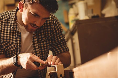 simsearch:6102-07158067,k - Carpenter working on his craft in a dusty workshop Stock Photo - Premium Royalty-Free, Code: 6109-08481963