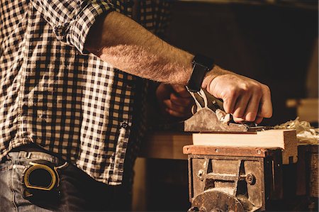 simsearch:6102-07158067,k - Carpenter working on his craft in a dusty workshop Stock Photo - Premium Royalty-Free, Code: 6109-08481964