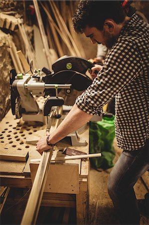 simsearch:6102-07158067,k - Carpenter working on his craft in a dusty workshop Stock Photo - Premium Royalty-Free, Code: 6109-08481985