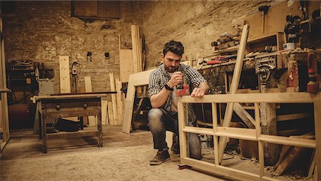 simsearch:6102-07158067,k - Carpenter working on his craft in a dusty workshop Stock Photo - Premium Royalty-Free, Code: 6109-08481988