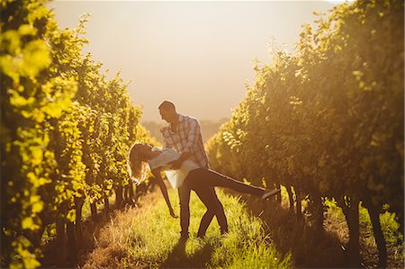 simsearch:6109-08204218,k - Couple dancing between grapevine at vineyard against sundown Stock Photo - Premium Royalty-Free, Code: 6109-08488644