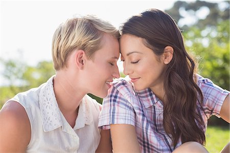 Lesbian couple giving head to head sitting in the park Stock Photo - Premium Royalty-Free, Code: 6109-08488601