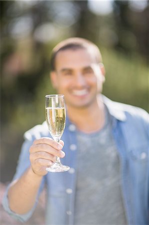 simsearch:614-06813654,k - Smiling man looking at a glass of champagne in garden Foto de stock - Sin royalties Premium, Código: 6109-08488969
