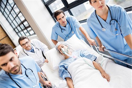 doctor intern male white - Medical team pushing patient on trolley at the hospital Stock Photo - Premium Royalty-Free, Code: 6109-08488938
