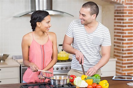 simsearch:6109-08390293,k - Smiling couple preparing vegetables in the kitchen at home Stock Photo - Premium Royalty-Free, Code: 6109-08489052