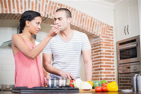 simsearch:6109-08390293,k - Smiling couple preparing vegetables in the kitchen at home Stock Photo - Premium Royalty-Free, Code: 6109-08489057