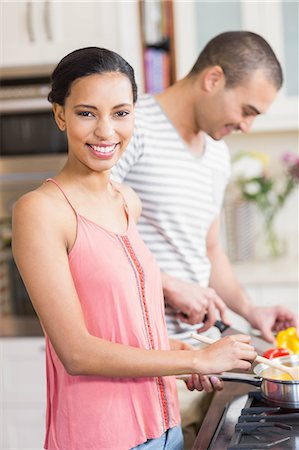 simsearch:6109-08390293,k - Smiling couple preparing vegetables in the kitchen at home Stock Photo - Premium Royalty-Free, Code: 6109-08489054
