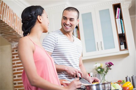 simsearch:6109-08390293,k - Smiling couple preparing vegetables in the kitchen at home Stock Photo - Premium Royalty-Free, Code: 6109-08489055