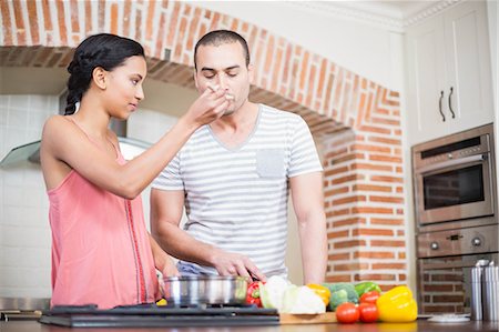 simsearch:6109-08390293,k - Smiling couple preparing vegetables in the kitchen at home Stock Photo - Premium Royalty-Free, Code: 6109-08489056