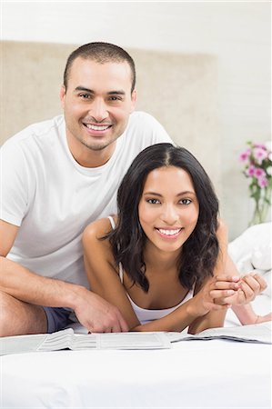 Happy couple reading in the bed at home in the bedroom Stock Photo - Premium Royalty-Free, Code: 6109-08489166