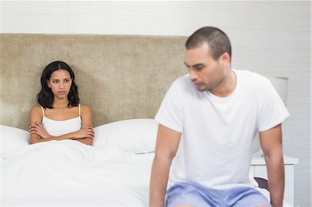 simsearch:6109-07601529,k - Upset couple sitting on bed after having an argument at home Stock Photo - Premium Royalty-Free, Code: 6109-08489170