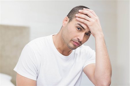 simsearch:6109-07601529,k - Upset man sitting on bed after having an argument at home Stock Photo - Premium Royalty-Free, Code: 6109-08489182