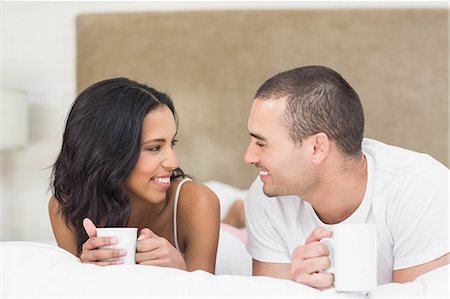 simsearch:6109-07497311,k - Smiling couple drinking coffee lying on the bed in the bedroom at home Stock Photo - Premium Royalty-Free, Code: 6109-08489129
