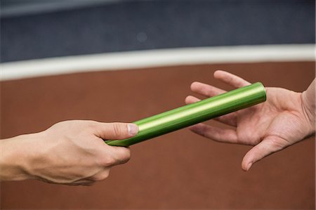 simsearch:400-05112689,k - Man passing the baton to partner on track at the gym Stock Photo - Premium Royalty-Free, Code: 6109-08489486
