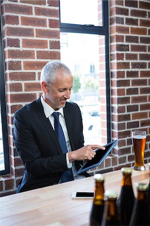 simsearch:6109-06684997,k - Businessman using tablet in a pub Stock Photo - Premium Royalty-Free, Code: 6109-08489679