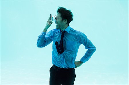 swimming class - Businessman on the phone underwater in swimming pool Stock Photo - Premium Royalty-Free, Code: 6109-08489778