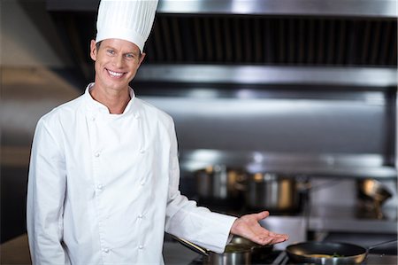 simsearch:6109-07601170,k - Happy chef smiling at camera in a commercial kitchen Stock Photo - Premium Royalty-Free, Code: 6109-08489846