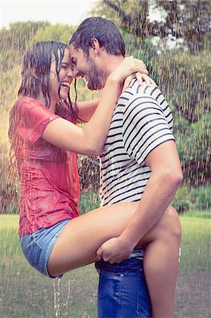 rain in women - Handsome man carrying his girlfriend under the rain in the park Stock Photo - Premium Royalty-Free, Code: 6109-08434617