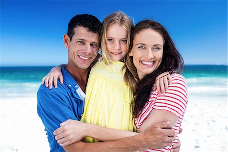 Cute family smiling and hugging on the beach Stock Photo - Premium Royalty-Free, Code: 6109-08434753