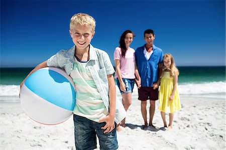 Cute family holding beach ball on the beach Stock Photo - Premium Royalty-Free, Code: 6109-08434762