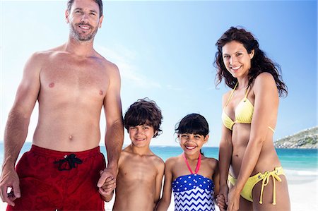 picture of boy and girl in swimsuits - Cute family holding hands on the beach Stock Photo - Premium Royalty-Free, Code: 6109-08434812