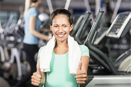 exercise machine - Smiling pregnant woman with towel around neck showing thumbs at the leisure center Stock Photo - Premium Royalty-Free, Code: 6109-08435110