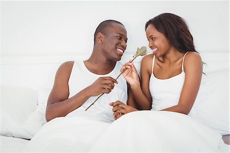 simsearch:6109-07497311,k - Man offering a flower to his girlfriend sitting on their bed Stock Photo - Premium Royalty-Free, Code: 6109-08435249