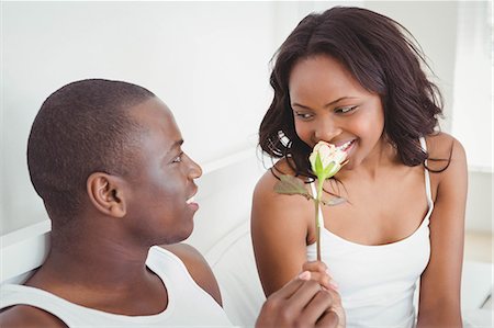 simsearch:6109-07497311,k - Man offering a flower to his girlfriend sitting on their bed Stock Photo - Premium Royalty-Free, Code: 6109-08435250