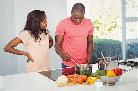 simsearch:6109-08390293,k - Ethnic couple cooking in the kitchen Stock Photo - Premium Royalty-Free, Code: 6109-08435387