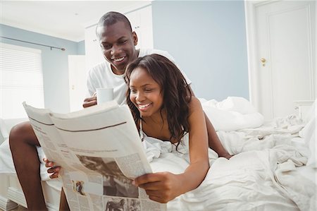 Ethnic couple reading the news in the bedroom Stock Photo - Premium Royalty-Free, Code: 6109-08435517