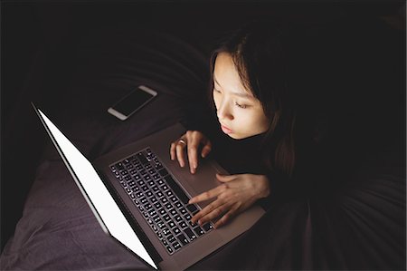 simsearch:6109-07497438,k - Brunette using laptop lying on the bed at home Stock Photo - Premium Royalty-Free, Code: 6109-08435638