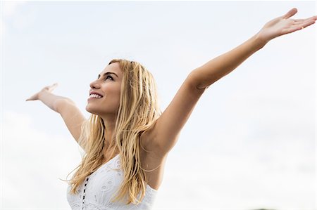 simsearch:6109-08481684,k - Beautiful blonde woman with arms outstretched in the coastline Foto de stock - Sin royalties Premium, Código: 6109-08435739