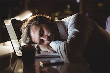 Businessman sleeping on his laptop at night Stock Photo - Premium Royalty-Free, Code: 6109-08581420