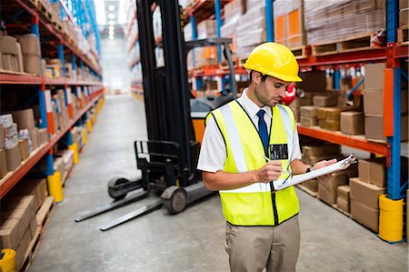 Warehouse manager checking list on his clipboard Stock Photo - Premium Royalty-Free, Code: 6109-08581550