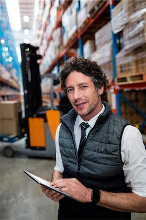 Warehouse manager using a tablet computer Stock Photo - Premium Royalty-Free, Code: 6109-08581582