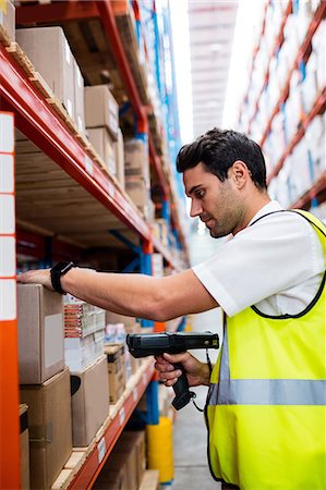 scanner - Warehouse manager with yellow coat scanning barcode on box Stock Photo - Premium Royalty-Free, Code: 6109-08581537