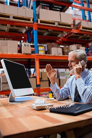 simsearch:400-04283915,k - Warehouse manager using a laptop talking on the phone Stock Photo - Premium Royalty-Free, Code: 6109-08581655