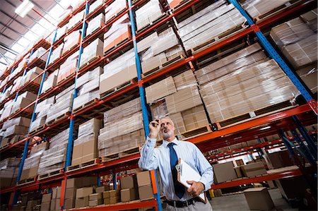 simsearch:400-04283915,k - Low angle view of warehouse manager holding a clipboard Stock Photo - Premium Royalty-Free, Code: 6109-08581633