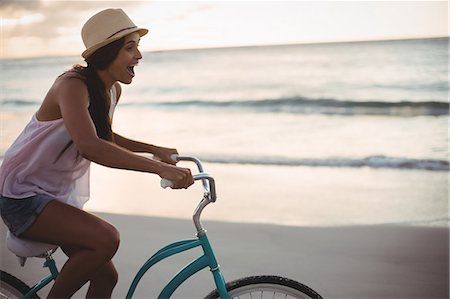 fit (tight clothes) - Young woman cycling on the beach Stock Photo - Premium Royalty-Free, Code: 6109-08582096