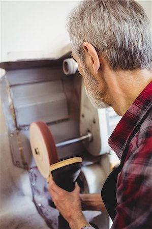 simsearch:6109-08582278,k - Rear view of cobbler using a sander machine Stock Photo - Premium Royalty-Free, Code: 6109-08582243