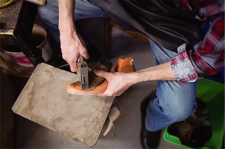 simsearch:6109-08582278,k - Overhead of cobbler stapling a shoe Stock Photo - Premium Royalty-Free, Code: 6109-08582266