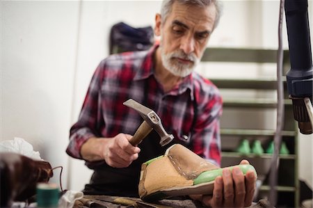 simsearch:6109-08582278,k - Low angle view of cobbler hammering on a shoe Stock Photo - Premium Royalty-Free, Code: 6109-08582281
