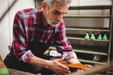 simsearch:6109-08582278,k - Side view of cobbler checking a shoe Stock Photo - Premium Royalty-Free, Code: 6109-08582282